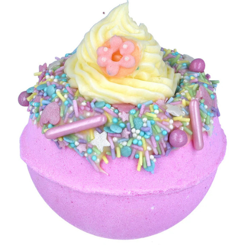 Pastel-colored bath bomb with decorative top on a white background