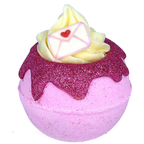 Pink bath bomb with yellow top and heart detail on a white background